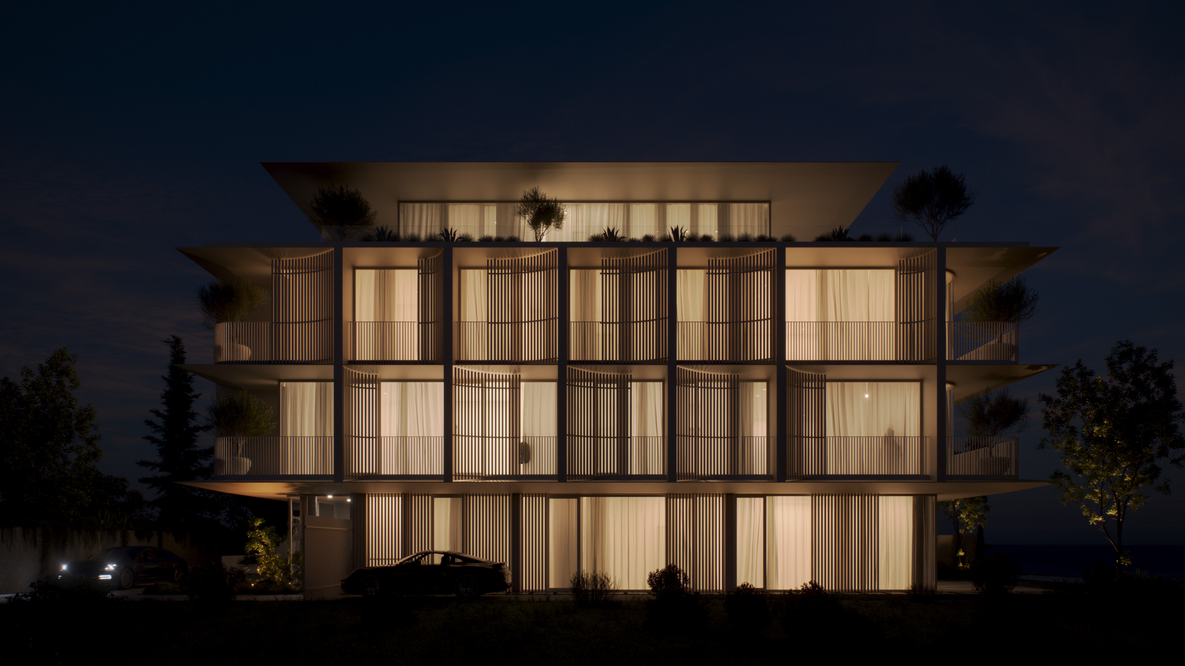 The front face of the facade in the Komo building at night with lighted homes in the inside.